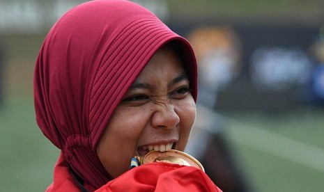 Atlet panahan putri Indonesia Sri Ranti menggigit medali emas setelah menjuarai final nomor compound putri SEA Games XXIX di Synthetic Turf Fild, kawasan Stadion Bukit Jalil, Kuala Lumpur, Malaysia, Rabu (16/8). 