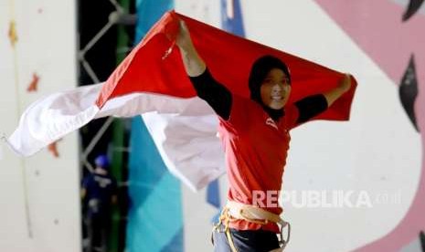 Atlet panjat tebing Indonesia Aries Susanti Rahayu mengibarkan Bendera Merah Putih setelah berhasil meraih medali emas pada kategori speed Asian Games 2018 di Arena Panjat Tebing Jakabaring Sport City, Palembang, Sumatera Selatan, Kamis (23/8).