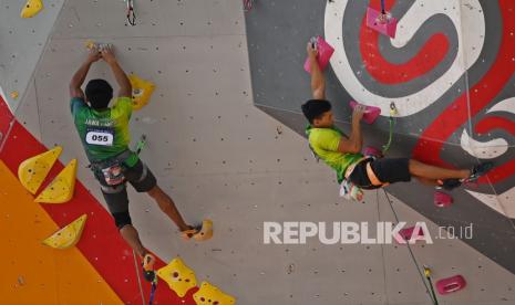 Atlet panjat tebing Jawa Timur Akbar huda (kiri) dan Rindi Sufriyanto (kanan) beraksi dalam babak kualifikasi nomor lead tim putra cabang panjat tebing PON Papua di Arena Panjat Tebing SP 2 Kabupaten Mimika, Papua, Rabu (29/9/2021).