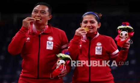 Atlet para-badminton Hary Susanto bersama Leani Ratri Oktila berpose dengan medali emas usai menundukkan atlet para-badminton Prancis Lucas Mazur dan Faustine Noel pada final ganda campuran SL3-SU5 Paralimpiade Tokyo 2020 di Yoyogi National Stadium, Tokyo, Jepang.