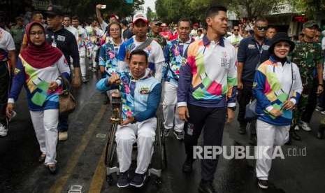 Atlet Paragames, Jaenal Aripin (tengah) bersama Ketua INAPGOC, Raja Sapta Oktohari (kedua kanan) membawa lentera api pada Pawai Api Obor Asian Para Games 2018 di Solo, Jawa Tengah, Rabu (5/9).