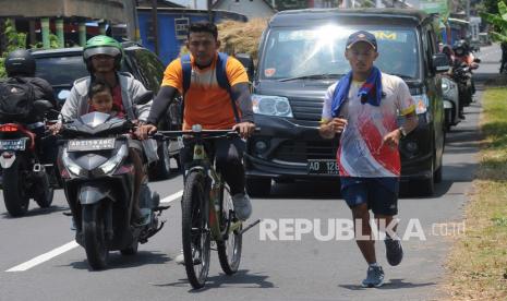 Atlet pencak silat Khoirudin Mustakim (kanan) melakukan nazar lari dari Salatiga ke Klaten di Karanganom, Klaten, Jawa Tengah, Senin (18/10/2021). Khoirudin Mustakim merupakan atlet pencak silat Jawa Tengah yang berhasil meraih mendali emas pada PON XX Papua melakukan nazar dengan lari dari Salatiga ke Klaten sebagai rasa syukur atas kemenangannya.