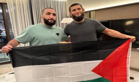 Atlet petarung gaya campuran UFC Khamzat Chimaev (kanan) membentangkan bendera Palestina. 