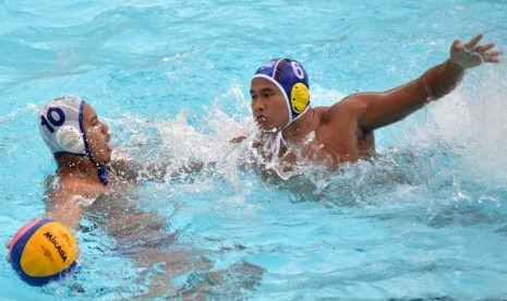 Atlet polo air Jabar Fakri Mahmud (kiri) berusaha melewati atlet polo air Sumsel M. Nurdiansyah pada pertandingan Semifinal Polo Air PON XIX Jabar di Stadion Renang Jalak Harupat, Kabupaten Bandung, Senin (19/9). 