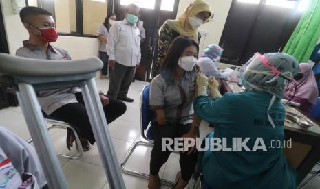 Atlet sekaligus Ketua National Paralimpic Committee (NPC) Kota Kediri Nanda Mei Sholiha (kedua kanan) mendapatkan suntikan vaksin COVID-19 di Kota Kediri, Jawa Timur, Rabu (28/4/2021). Sejumlah atlet disabilitas tersebut mendapatkan vaksin COVID-19 sebagai persiapan mengikuti Pekan Paralimpik Provinsi Jawa Timur bulan Mei mendatang. 