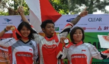 Atlet sepeda MTB Down Hill putra Indonesia, Purnomo (tengah), bersama rekannya Risa Suseanty (kiri) dan Fitriyanti Riyanti memgang medali SEA Games XXVI mereka di Sebek, Gunung Pancar, Bogor, Jabar, Sabtu (12/11).