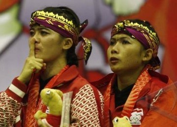 Atlet silat Indonesia, Ni Made Dwi Yanti (kanan) dan Sang Ayu Ketut Wilantri, menangis saat menyanyikan lagu Indonesia Raya saat penyerahan medali emas nomor seni beladiri dobel putri pencak silat Sea Games XXVI di Padepokan Pencak Silat, Taman Mini Indone