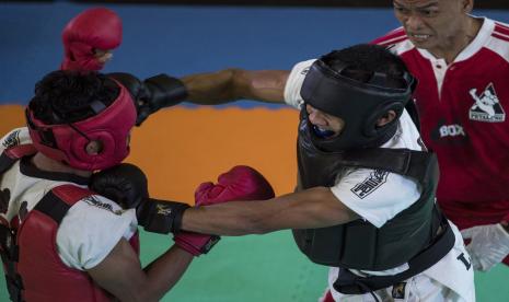 Atlet tarung derajat Lampung Chairul Naim (kanan) memukul atlet tarung derajat Jambi Rangga Adi Brata (kiri) saat bertanding pada semi final Tarung Derajat kelas 52,1-55kg PON Papua di GSG Eme Neme Yauware, Kabupaten Mimika, Papua, Ahad (10/10/2021).