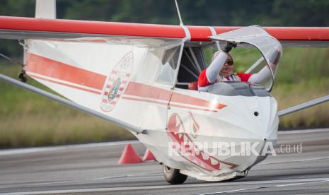 Atlet terbang layang DKI Jakarta Adelya keluar dari pesawatnya usai bertanding dalam nomor precision landing dual seater putri cabang terbang layang PON Papua di Landasan udara TNI AU Kabupaten Mimika, Papua, Senin (4/10/2021).