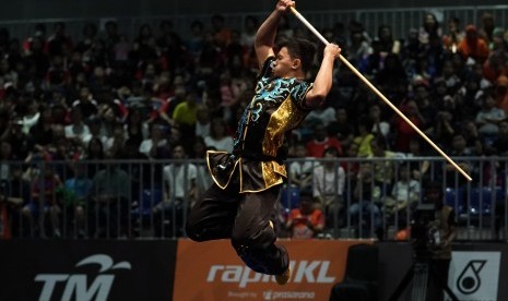 Atlet wushu Indonesia Achmad Hulaefi memperagakan jurus dalam nomor gabungan gunshu dan daoshu.