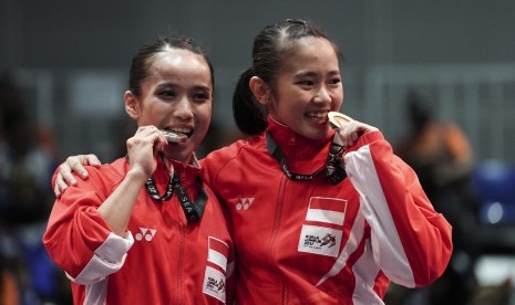 Atlet Wushu Indonesia Felda Elfira Santoso (kanan) dan Monica Fransisca Sugianto menggigit medali ketika penganugerahan juara Wushu nomor Daoshu putri SEA Games XXIX di KLCC, Kuala Lumpur, Malaysia, Senin (21/8). Felda Elfira berhasil meraih medali emas dan Monica Fransisca merebut medali perak. 