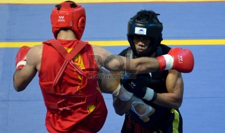  Atlet wushu IndonesiaT arigan Hendrik (hitam) saat melawan atlet wushu asal Iran Aly Yousefi dalam final nomor wushu sanda kategori 60kg Islamic Solidarity Games di Jakabaring, Palembang,Sumsel, Selasa (1/10).  (Republika/Prayogi)