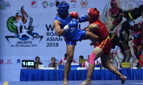 Atlet wushu putra Sumut Jeka Asparido Saragih (kiri) menendang atlet wushu putra Jawa Barat Bagus Nurul Anwar dalam nomor sanda wushu putra di Sport Mall Britama Arena, Kelapa Gading, Jakarta, Kamis (26/10).