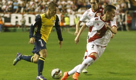 Atletico Madrid's Antoine Griezmann (L) and Rayo Vallecano's Roberto Triguero and Jose Baena (C) challenge for the ball during their Spanish first division soccer match at at Vallecas stadium in Madrid August 25, 2014