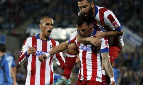 Atletico Madrid's Mario Mandzukic celebrates with teammates Arda Turan (R) and Joao Miranda (L) after scoring a goal against Getafe next to teammate Arda Turan during their Spanish first division soccer match at Coliseum Alfonso Perez stadium in Getafe, ne