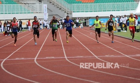 Atlet melakukan adu kecepatan pada kelas lari 100 meter putra di stadion Pakansari, Cibinong, Jawa Barat, Kamis (22/9). 