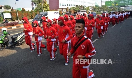  Atlit peserta mengikuti kirab Api PON XIX saat melintasi Jl Ahmad Yani, Bekasi, Jawa Barat. Selasa (13\9).