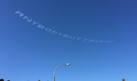 Atraksi lima pesawat yang menuliskan pesan di langit berisi ejekan untuk Donald Trump saat Rose Parade di Pantai Pasadena, AS.