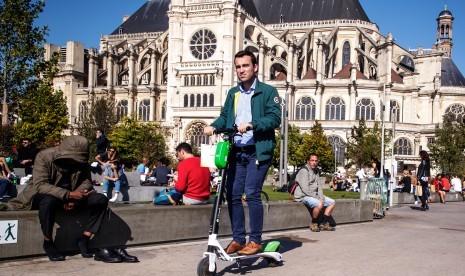 Pria naik skuter listrik di jalanan kota Paris, Prancis. Utilitas Prancis EDF melihat output listriknya turun ke level terendah dalam 30 tahun.