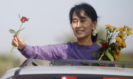 Aung San Suu Kyi menggenggam mawar yang diberikan para pendukungnya kala mengunjungi daerah pemilihan Kawhnu.