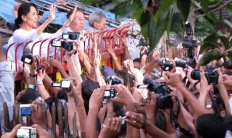 Aung San Suu Kyi saat menyapa pendukungnya di gerbang rumah bersejarah