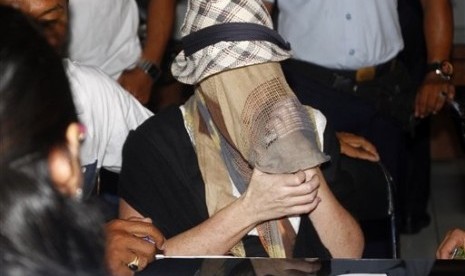 Australian Schapelle Corby, covering her face, gestures at the correctional office after she received her parole in Bali, Indonesia, Monday, Feb. 10, 2014.  