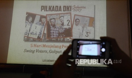 Awak media mengabadikan slide yang ditunjukan oleh peneliti Lingkaran Survey Indonesia (LSI) Ardian Sopa saat menggelar diskusi temuan survey swing voters, golput dan money politik di Kantor LSI, Jakarta, Jumat (10/2).