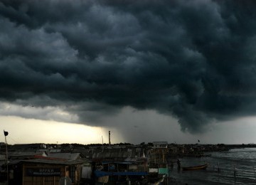 Awan hitam menyelimuti kawasan Muara Angke, Jakarta Utara, Kamis (5/1). (Republika/Agung Supriyanto)