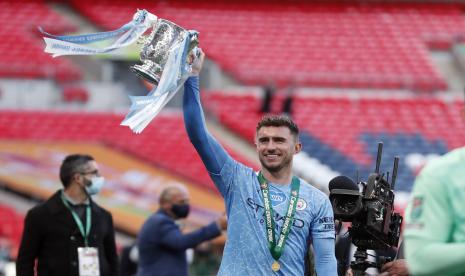 Aymeric Laporte dari Manchester City merayakan dengan trofi di akhir pertandingan final Piala Liga Inggris antara Manchester City dan Tottenham Hotspur di stadion Wembley di London, Minggu, 25 April 2021. Manchester City menang 1-0.