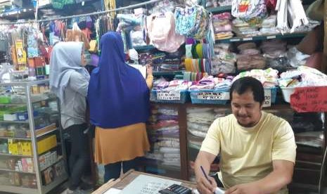 Azzan Awod Bazri, pemilik pusat oleh-oleh haji/umrah Toko Apeh, Jl RE Martadinata, Kabupaten Purwakarta, sedang melayani pembeli, Jumat (10/8). 