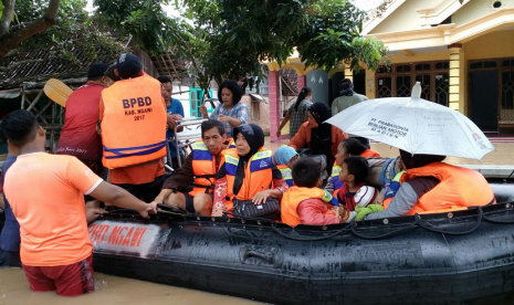 Badan Penanggulangan Bencana Daerah (BPBD) Kabupaten Ngawi membantu proses evakuasi warga terdampak banjir. 