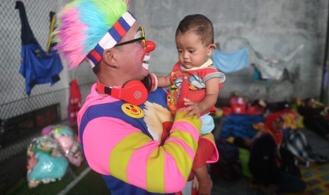 Badut dari Aku Badut Indonesia menghibur anak korban bencana tsunami di pengungsian Labuan, Pandeglang, Banten, Kamis (27/12/2018).