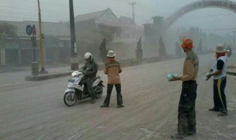 Bagikan masker ke pengguna jalan