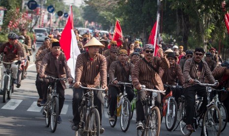 Bakal calon anggota legislatif dan simpatisan Partai Demokrasi Indonesia Perjuangan (PDIP) menaiki sepeda ontel menuju kantor Komisi Pemilihan Umum (KPU) untuk mendaftar calon anggota legislatif di Solo, Jawa Tengah, Selasa (17/7). 