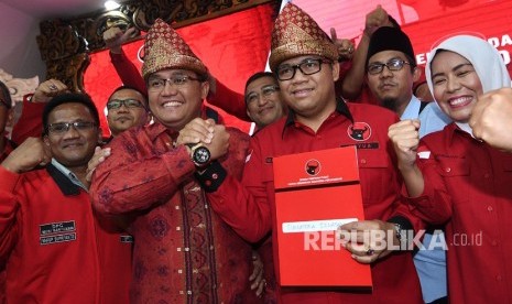 Bakal calon Gubernur dan Wakil Gubernur Sumsel Dodi Reza Alex Noerdin (ketiga kiri) dan Giri Ramanda Kiemas (ketiga kanan) berjabat tangan usai menerima berkas rekomendasi dukungan di kantor DPP PDIP, Lenteng Agung, Jakarta Selatan, Ahad (7/1). 