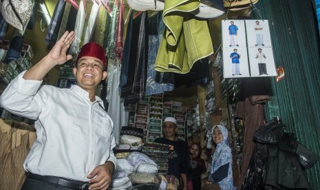 Bakal Calon Gubernur DKI Jakarta Anies Baswedan memberi salam saat membeli peci khas Betawi di Blok F Pasar Tanah Abang, Jakarta, Jumat (21/10). 