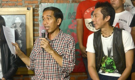 Bakal calon presiden (capres) Joko Widodo (kiri) bersama personil Slank, Bimbim (kanan) memberi keterangan kepada wartawan usai melakukan pertemuan tertutup di markas Slank, Jl Potlot, Jakarta, Selasa (27/5). 