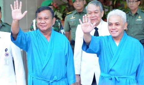 Bakal calon presiden dan wakil presiden dari poros Partai Gerindra-Partai Amanat Nasional (PAN) Prabowo Subianto (kiri) dan Hatta Rajasa menyapa wartawan sebelum menjalani tes kesehatan di Rumah Sakit Pusat Angkatan Darat (RSPAD) Gatot Subroto, Jakarta, Ju