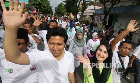 Bakal calon Wakil Gubernur Jawa Timur Emil Elestianto (kiri) didampingi istri Arumi Bachsin (kedua kiri) mengikuti jalan sehat dan deklarasi dukungan, di Pare, Kediri, Jawa Timur, Ahad (21/1). 