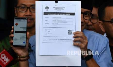 Bakal calon wakil presiden Pilpres 2019 Sandiaga Uno (kanan) menunjukkan tanda terima Laporan Harta Kekayaan Penyelenggara Negara (LHKPN) di gedung KPK, Jakarta, Selasa (14/8).