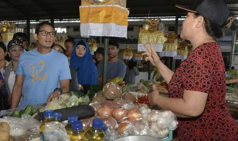 Bakal Calon Wakil Presiden Sandiaga Uno (kiri) berbincang dengan pedagang saat mengunjungi Pasar Sindhu di Sanur, Denpasar, Bali, Minggu (9/9).