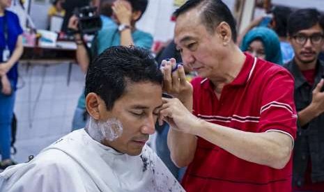 Bakal calon Wakil Presiden Sandiaga Uno memotong rambut di pangkas rambut Ko Tang, Glodok, Jakarta, Selasa (11/9). 