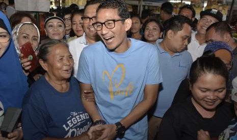 Bakal Calon Wakil Presiden Sandiaga Uno (tengah) berbincang dengan pedagang saat mengunjungi Pasar Sindhu di Sanur, Denpasar, Bali, Minggu (9/9).