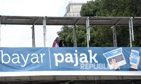 Baliho himbauan membayar pajak dipajang di JPO Gambir, Jakarta, Ahad (24/4).(Republika/ Wihdan)