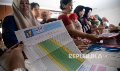  Balita bersama orang tua bersiap melakukan penimbangan di Posyandu.