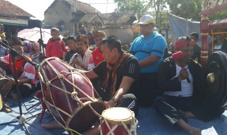 Balongub Jabar Tb Hasanuddin tengah menabuh kendang dalam acara Jumat Bersih yang disertai pertunjukkan pencak silat di bantaran Sungai Citarum, Kabupaten Bandung, Jumat (9/2).