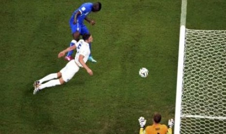 Balotelli mencetak gol ke gawang Joe Hart. 