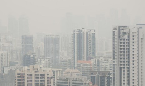 Bangunan menjulang di distrik finansial Singapura tampak terselimuti kabut asap, Senin (16/9). Kebakaran hutan di Indonesia menjadi penyebab kabut asap di Singapura.