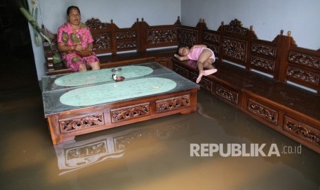 Banjir Di Kediri.  Warga beristirahat di dalam rumahnya yang terendam banjir di Desa Papar, Kediri, Jawa Timur, Kamis (21/3/2019).