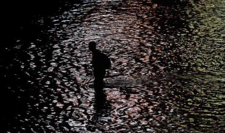  BANJIR JAKARTA. Warga melintasi salah satu ruas jalan Jakarta yang direndam banjir